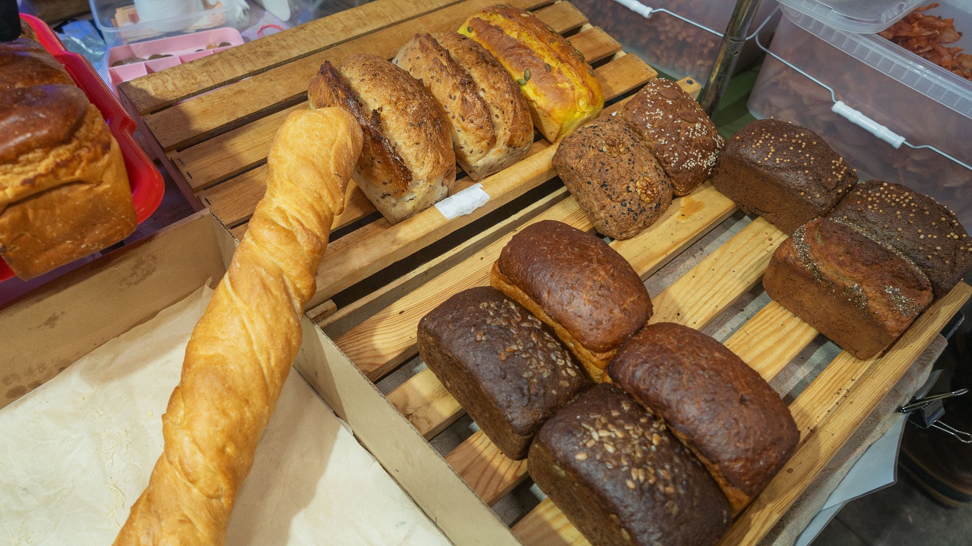 A vibrant display of freshly baked breads for sale, featuring homemade loaves, flaky croissants, and assorted flatbreads, inviting customers to indulge in delicious, artisanal flavors.